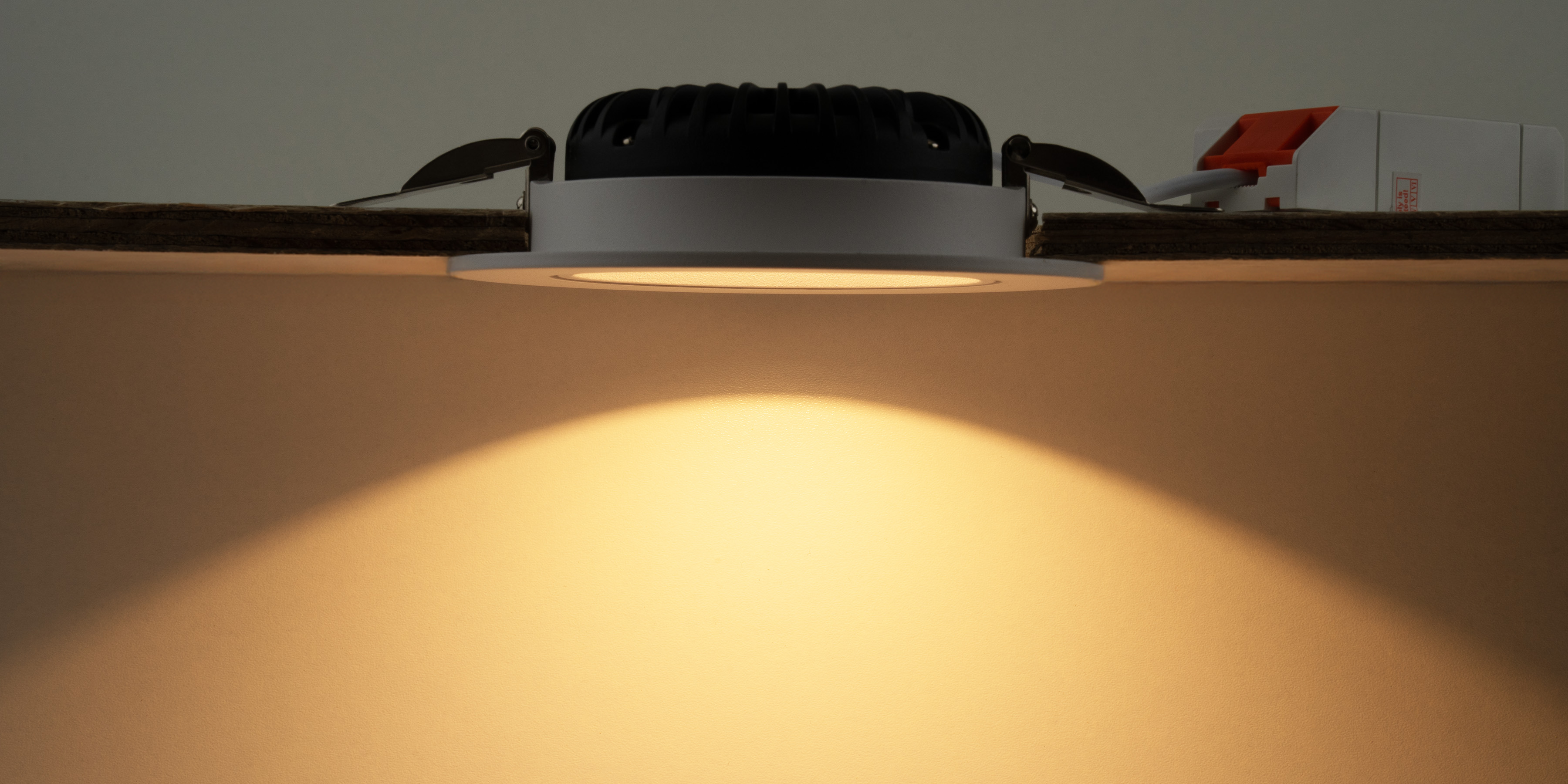 Grote witte LED-inbouwspot met lage inbouwdiepte die een brede lichtbundel naar beneden schijnt