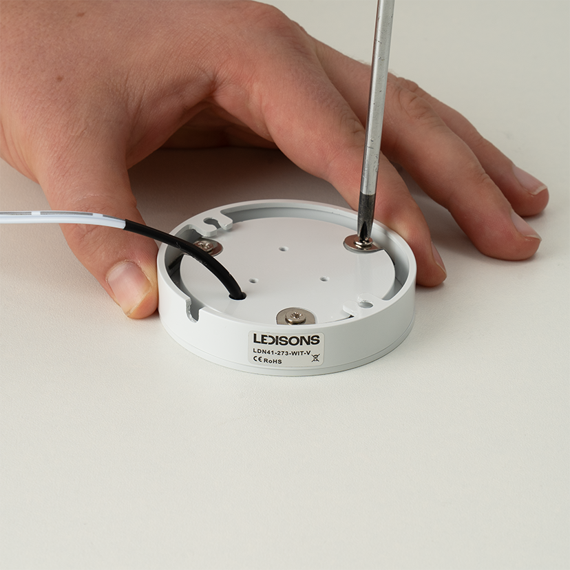 Frame van een LED-opbouwspot losdraaien met schroevendraaier voor installatie of onderhoud