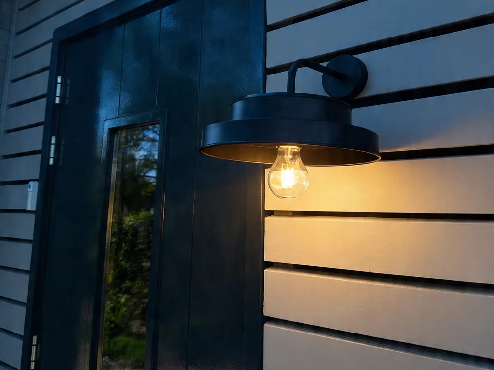 Stijlvolle wandlamp buiten naast de voordeur met warm licht voor een veilige en sfeervolle entree
