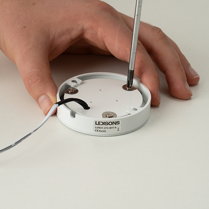 Behuizing van een LED-opbouwspot losdraaien met schroevendraaier voor installatie of onderhoud